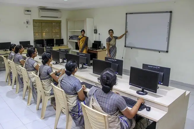 Students at computers in rows in the computer lab.