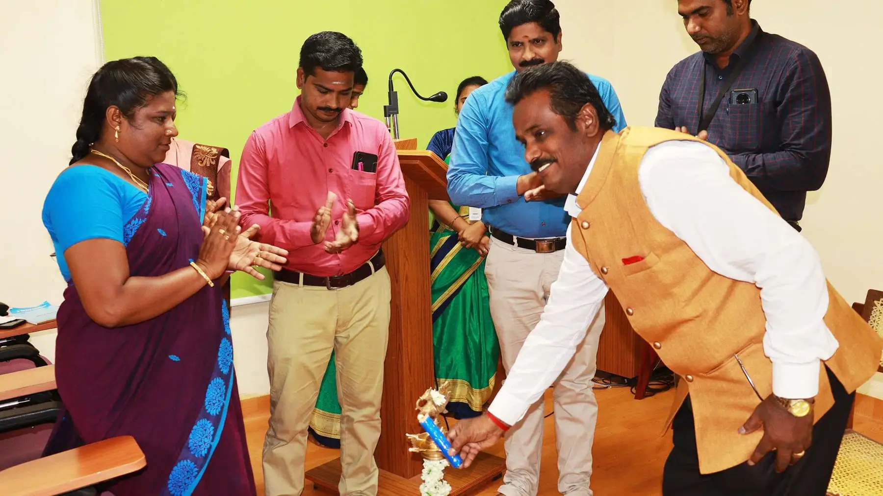 The guest lights the lamp at the opening of the programme, watched by faculty.