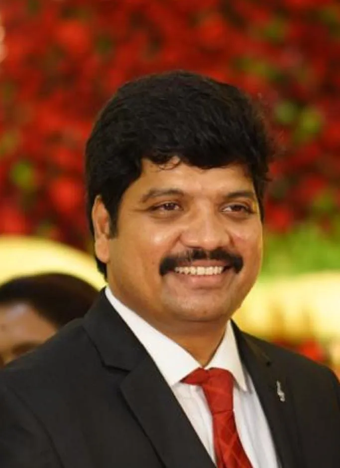 S. Senthil Kumar in a dark suit.