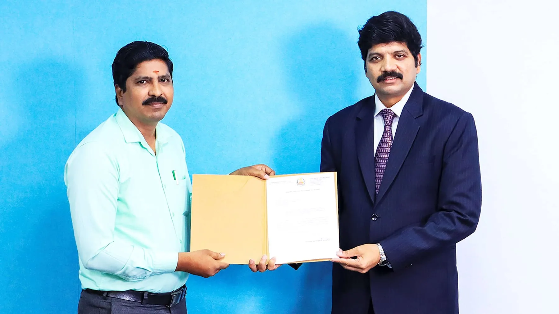 The Chairman hands a letter to the Principal.