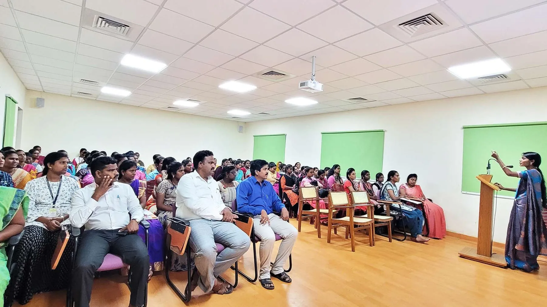 Students perform a short play at the front of the seminar hall.